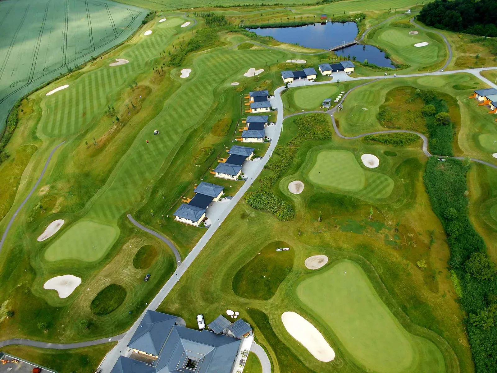 Vista aerea del Golf Resort Black Bridge, con appartamenti che costeggiano le fairway nel suo sito pianeggiante e aperto