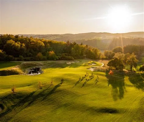 Fairway illuminata dal sole e colline boschive ondulate al Panorama Golf Resort, Kácov