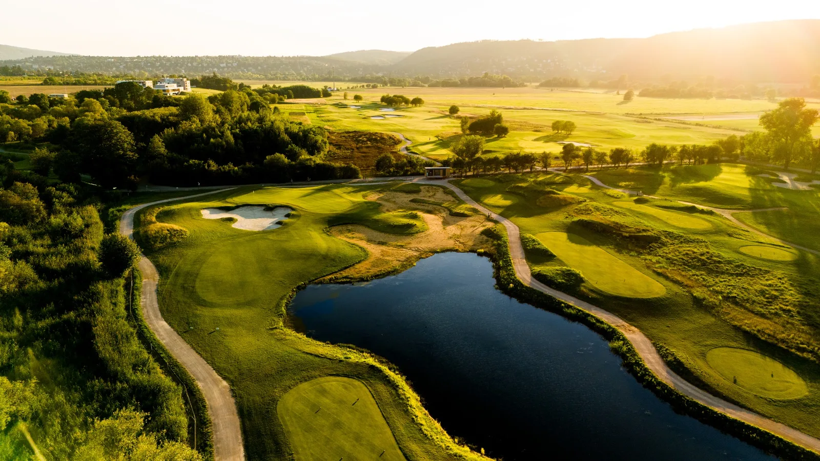 Un green protetto da aree di sabbia sotto il clubhouse di Prague City Golf Zbraslav