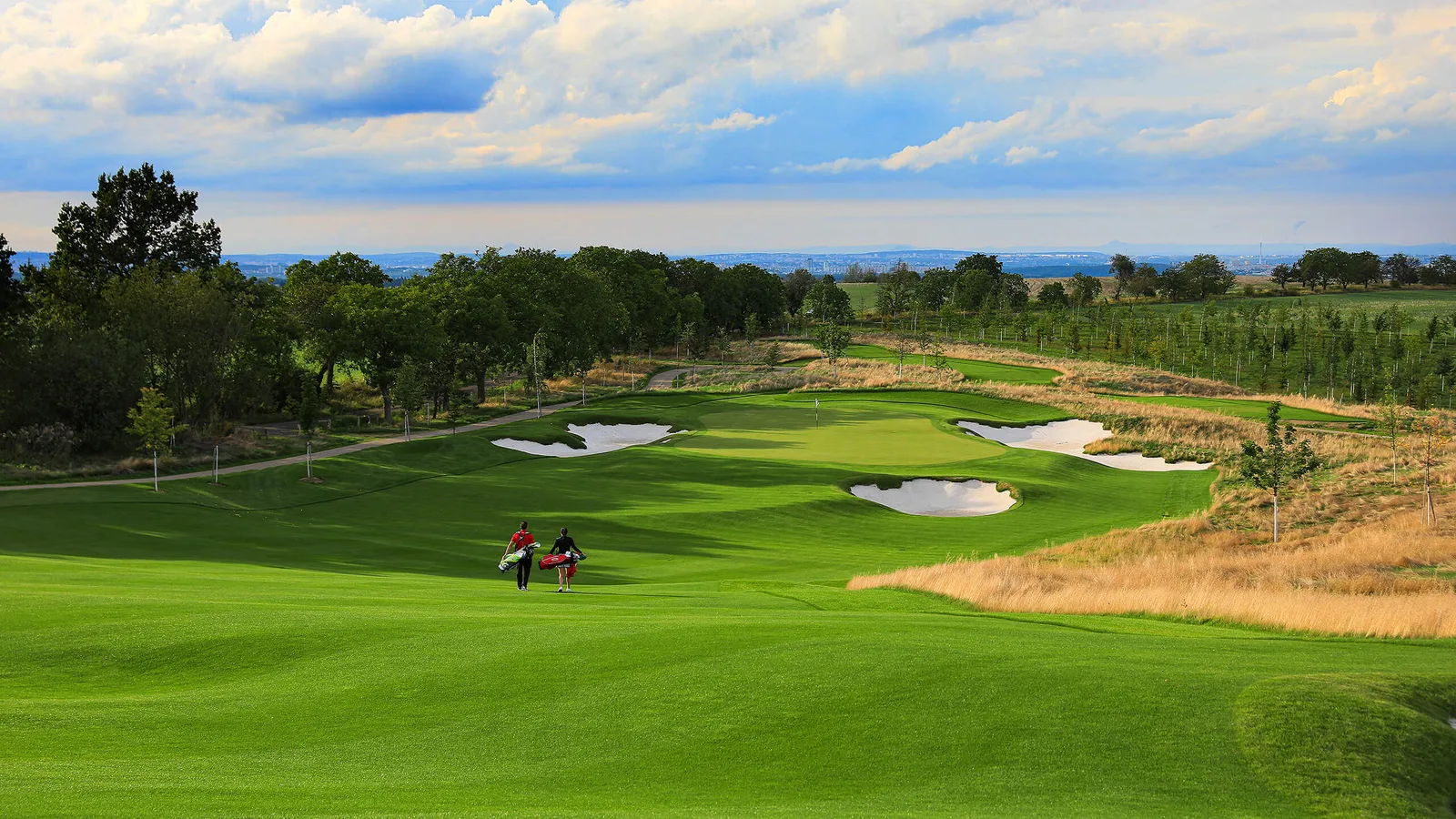Un green bunkerizzato al The Oaks, PGA National Repubblica Ceca, con lo skyline di Praga sullo sfondo al tramonto